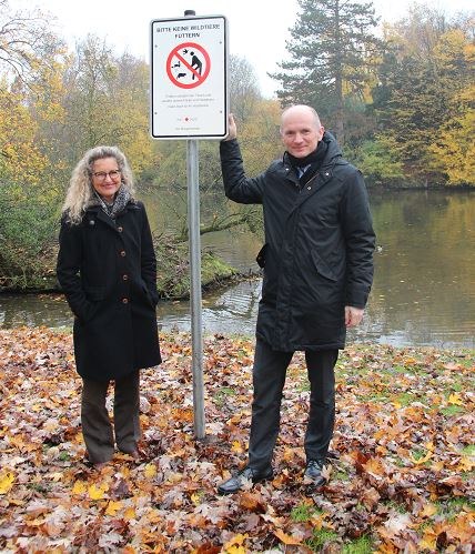 Umweltdezernent Dr. Matthias Welpmann und Henrike Mölleken, Leiterin des Amtes für Umwelt und Stadtgrün, an einem der neuen Schilder im Alten Stadtgarten.