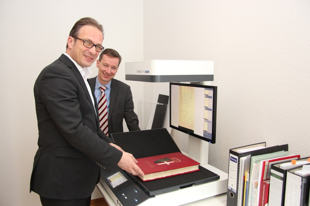 Bürgermeister Reiner Breuer und Dr. Jens Metzdorf, Leiter des Stadtarchivs, am neuen Buchscanner, mit dem das Goldene Buch digitalisiert wurde.