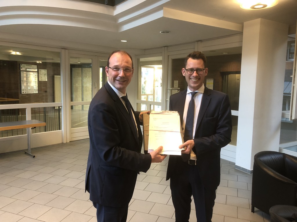 Planungsdezernent Christoph Hölters übergibt Dr. Richard Lehmann-Brauns, Projektleiter bei Krieger, die Baugenehmigung für den Sconto-Möbelmarktes im Hammfeld. 