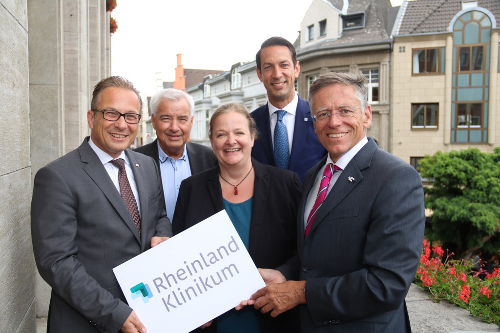 Bürgermeister Reiner Breuer (links) und Landrat Hans-Jürgen Petrauschke (rechts) freuen sich mit Patricia Mebes, Dr. Nicolas Krämer (2.v.r.) und Wilfried Jacobs (2.v.l.) über die Fusion zum Rheinland Klinikum Neuss.