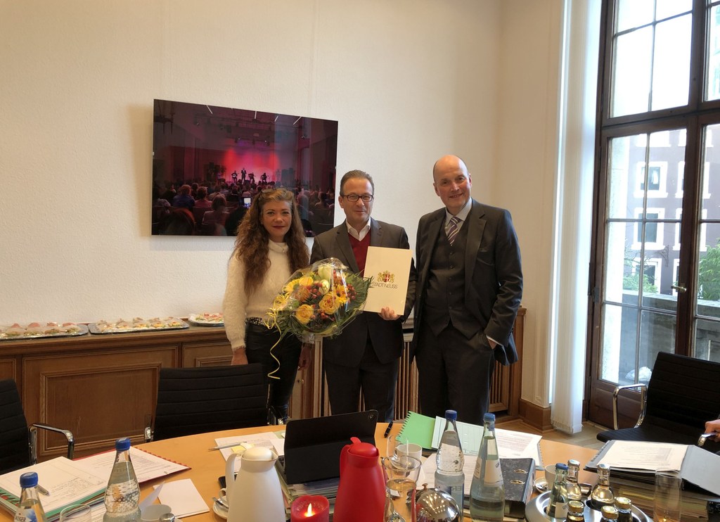 Der Erste Beigeordnete und Stadtkämmerer, Frank Gensler, und Cristina Pires, Vertreterin des Personalrates, überreichten Bürgermeister Reiner Breuer eine Urkunde und Blumen.
