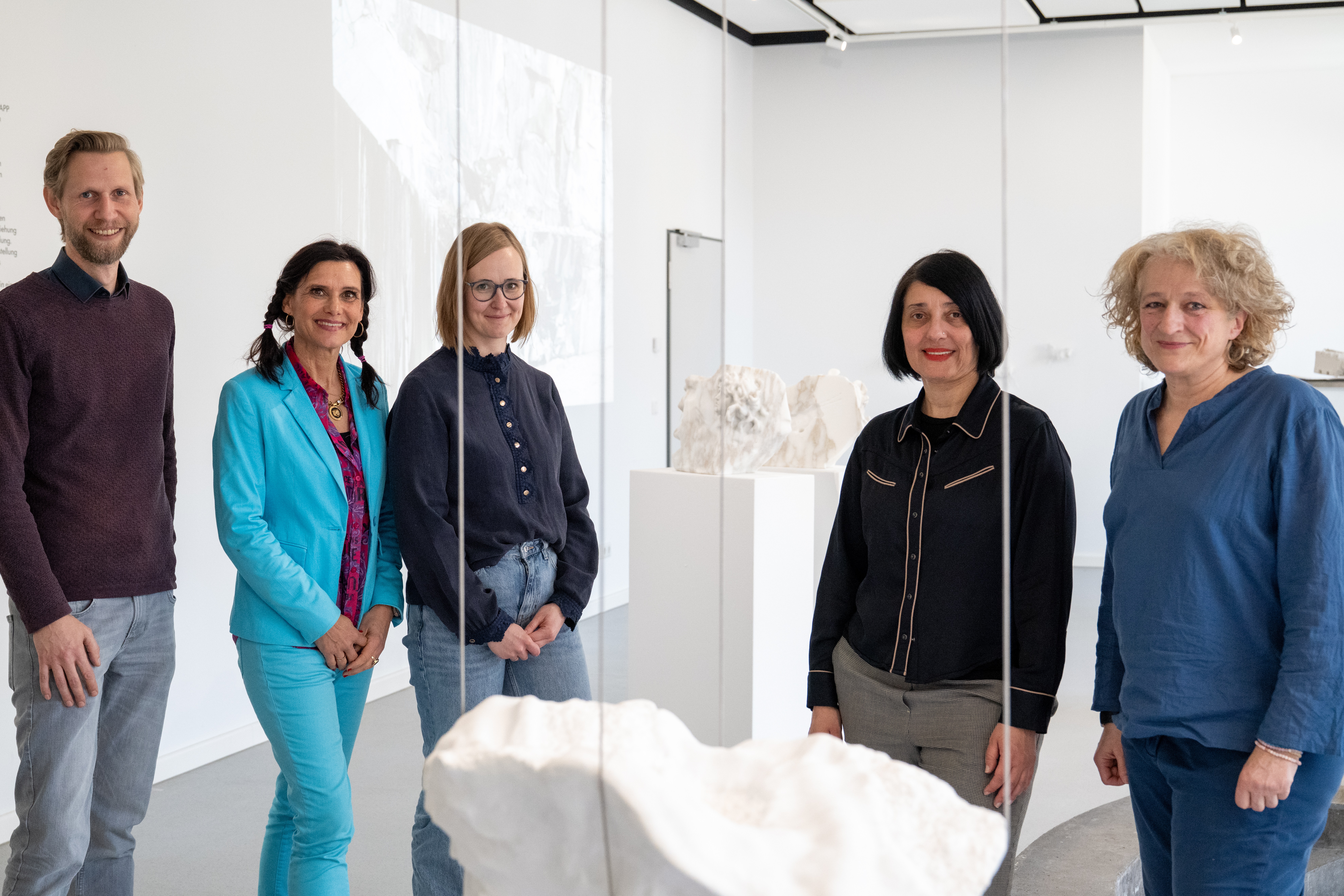 Eine kleine Gruppe Erwachsener in einem Ausstellungsraum 