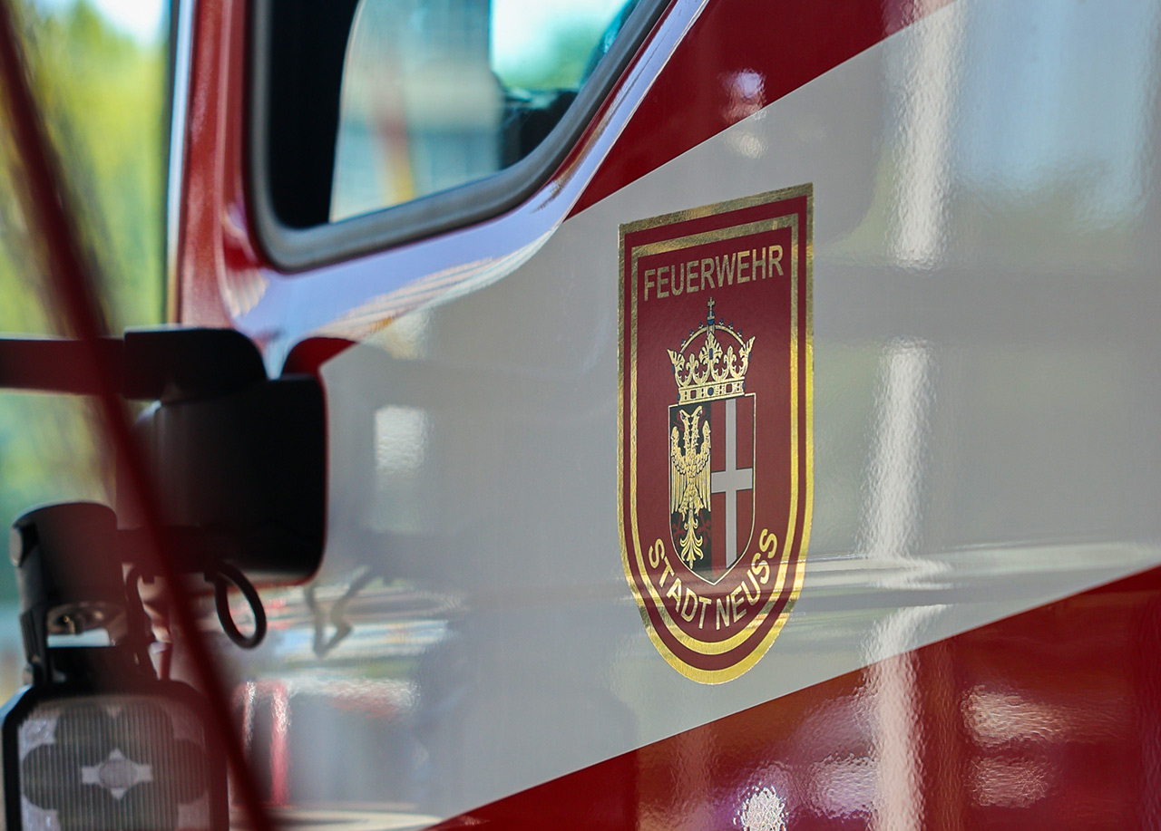 Fahrertür eines Feuerwehrwagens mit goldenem Stadtwappen