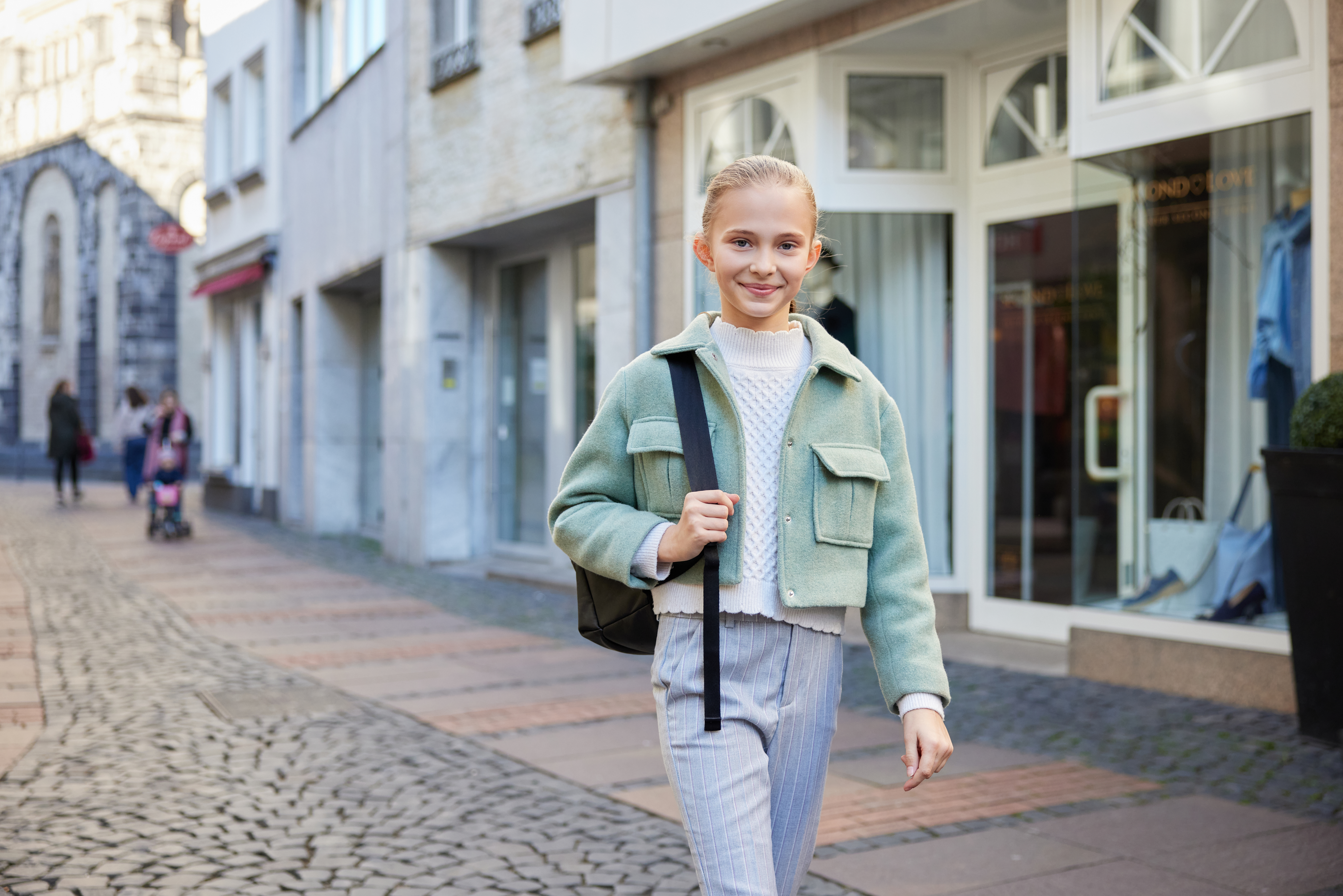 Ein Mädchen geht zu Fuß durch die Neusser Innenstadt.