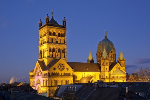 Abendliche Aufnahme des Quirinus-Münsters: vor einem tiefdunkelblauen Himmel erstrahlt das Neusser Wahrzeichen.