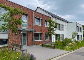 Moderne Wohnhäuser mit einer Fassade aus weißem Putz und Ziegeln.