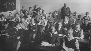 Schwarz-Weiß-Aufnahme von 29 Jungen und einen Lehrer in einem Klassenzimmer. Auf einer Tafel steht geschrieben: 1935 VI a