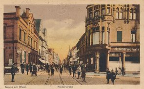 Colorierte Schwarz-Weiß-Foto mit Blick auf die Niederstraße. Es sind zahlreiche Menschen auf den Bürgersteigen und auf der Straße selbst unterwegs.