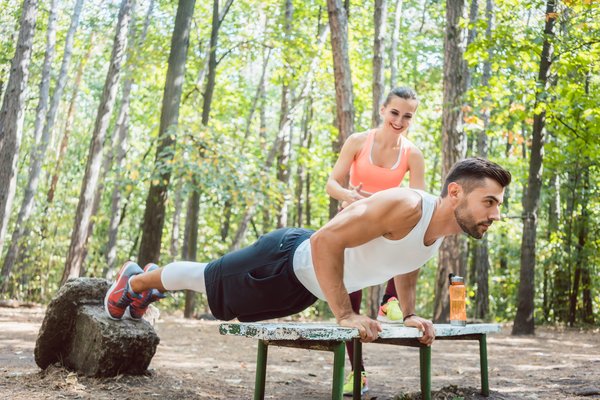 Ein sportlicher Mann mach Liegestütze im Park.