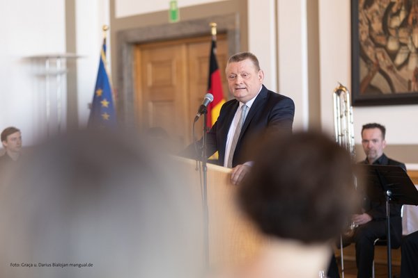 Dr. Hermann Gröhe steht hinter einem Rednerpult und hält seine Laudatio.