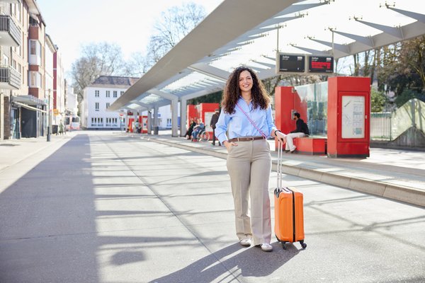 Frau mit Rollkoffer am Busbahnhof Zolltor