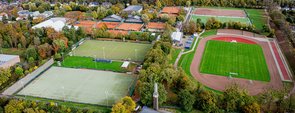 Drohnenaufnahme des Areals mit dem Hauptfeld links und zwei Hockeyfeldern links.