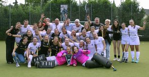Eine Gruppe von über 30 Spielerinnen und Trainer:innen jubelt in die Kamera.