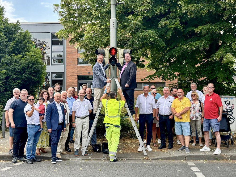 Eine Gruppe von Menschen steht vor einer Schützenampel 