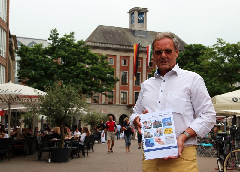 Beigeordneter a.D. Wilfried Kruse, Leiter der Enquetekommission, präsentiert den Abschlußbericht auf dem Neusser Markt vor dem Rathaus.
