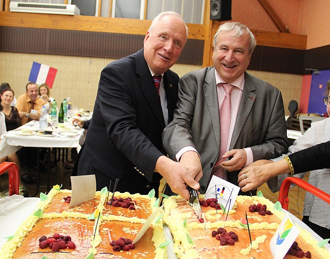 Bürgermeister Bruno Bourg-Broc und Erster Stellvertretender Neusser Bürgermeister Thomas Nickel schneiden gemeinsam die Geburtstagstorte an.